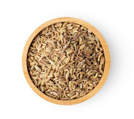fennel seeds in wood bowl on white background. top view