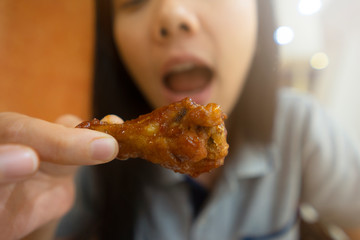 Women Eating delicious BBQ chicken wing