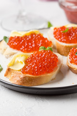 Red caviar on baguette toast with butter, appetizer for wine, champagne. Holiday, new year, Christmas, buffet. Delicious canape, food