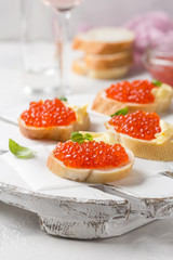 Red caviar on baguette toast with butter, appetizer for wine, champagne. Holiday, new year, Christmas, buffet. Delicious canape, food