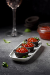 Red caviar in tartlets black, appetizer wine, champagne. Holiday, new year, Christmas, buffet. Delicious canape, food
