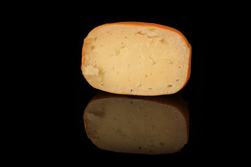 half of hard porous yellow edam cheese head with holes