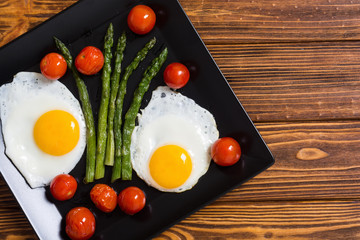 Healthy breakfast with eggs , asparagus and tomatoes