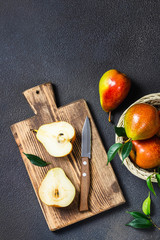 Ripe juicy pears sliced on cutting board. Top view, space for text.