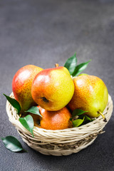 Pears in a basket on dark background. Top view, space for text.