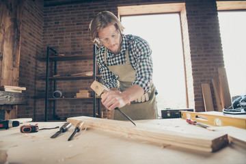 Portrait of his he nice handsome blond focused guy artisan builder woodworker grinding hard wood at industrial brick loft style interior workplace indoors