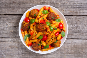 Italian penne pasta with meatballs and tomatoes