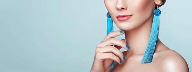 Fototapeten Beautiful woman with large earrings tassels jewelry blue color. Perfect makeup and nails manicure © Oleg Gekman