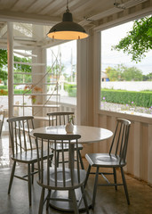 Wooden table with chairs with lamp lighting in cafe
