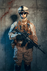 Special forces United States soldier or private military contractor holding rifle. Image on a dark background