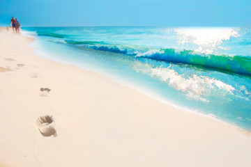 Seascape. White sand emerald ocean.Footprints in the sand of people walking along the shore