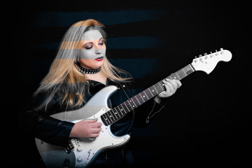 Fototapeta na wymiar Beautiful blonde girl in rock style on a black background.