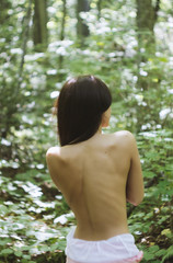 Back of a woman, she looking at the forest.