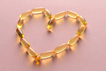 Close up capsules of fish fat oil in the heart shape, omega 3,