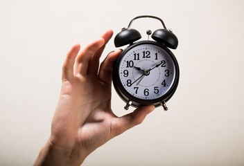 Hand Holding Alarm Clock