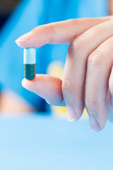 Closeup shot of a Female hand holding acapsule pill