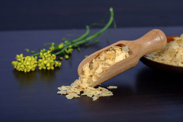 Cornflakes in wood spoon on a dark wooden background and copy