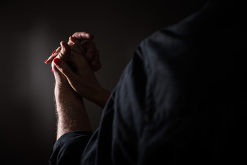 Closeup shot of illuminated dancers hands; a young couple - a woman and a man in a black shirt -...