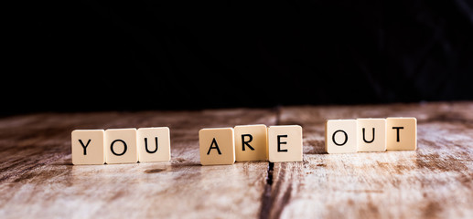 You are out word made of tiles on dark wooden background