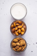 Three glasses with almonds at different stages of making milk from nuts