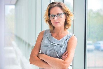 Portrait of confident businesswoman standing with arms crossed at new office