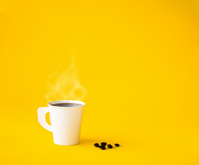 Paper Cup of coffee with smoke and Roasted coffee beans on yellow background. Copy space for your text