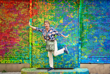 Middle age woman having fun in a city tour and posing so happy