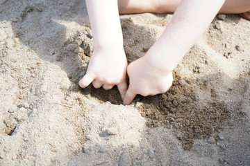 mains d'enfant dans le sable
