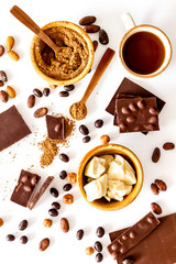 Different variety of chocolate and hazelnut on white background top view