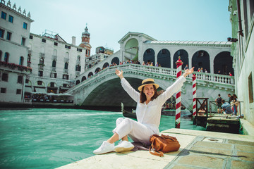 vrouw zitten in de buurt van de rialtobrug in venetië italië kijken naar grand canal met gondels