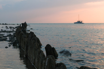 A beautiful sunset on the sea in the summer with a tender pink and orange and lilac color