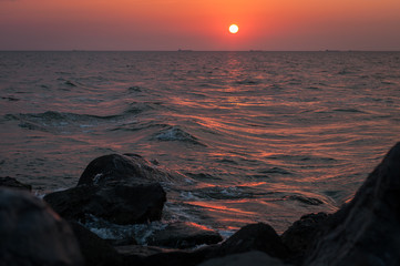 A beautiful sunset on the sea in the summer with a tender pink and orange and lilac color