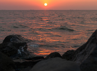 A beautiful sunset on the sea in the summer with a tender pink and orange and lilac color