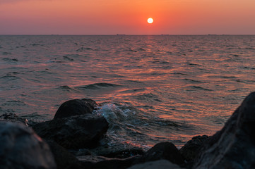 A beautiful sunset on the sea in the summer with a tender pink and orange and lilac color