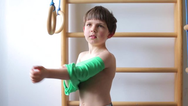 child takes off his shirt near a sports corner at school