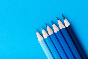Macro photograph of several pencils of blue color on a paper background - Powered by Adobe