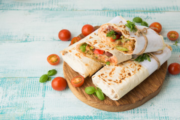Traditional Mexican food burritos with beans and vegetables. Vegetarian rolls with red beans and vegetables lie on an aged wooden table.