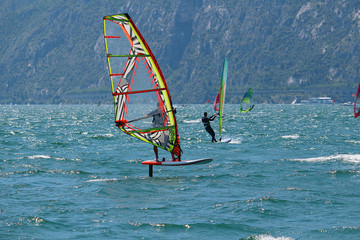 Windsurfer using a foilboard causing the board to leave the surface of the water (Lake Garda, Italy)