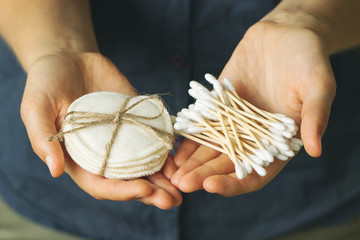 Set of eco-friendly body care items in the woman's hand. Reusable cotton pads, bamboo cotton buds. Zero waste concept, plastic-free, organic, eco-friendly shopping