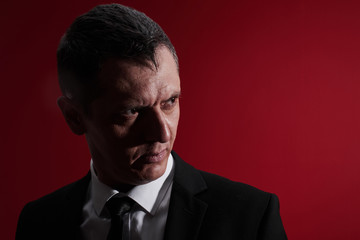 The evil boss. Portrait of an angry man in a business suit with red eyes with rage. Aggressive...