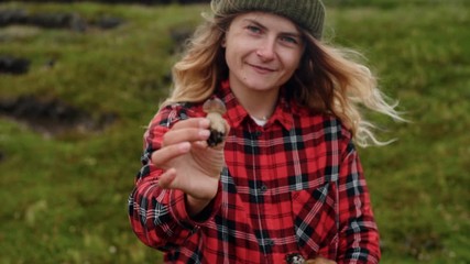 Young woman holds wild mushrooms in hands