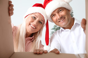 Happy mature couple opening Christmas present, bottom view