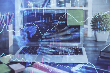 Financial chart drawing and table with computer on background. Multi exposure. Concept of...