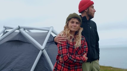 Young couple enjoys sunset at epic camping spot