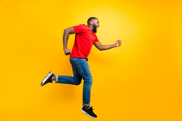 Full length body size photo of casual running man wearing jeans denim who aspires to achieve what he has planned while isolated with yellow background