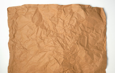crumpled piece of brown paper sheet on white background
