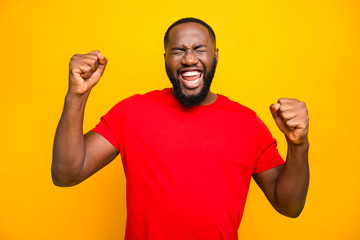 Photo of bearded overjoyed ecstatic man having won some competitions while isolated with yellow...