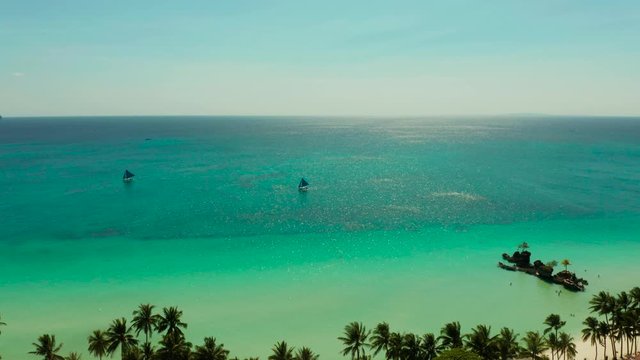 Tropical white sand beach with sailing yachts, hotels near the blue lagoon and corall reef. aerial view, Boracay, Philippines. Seascape with beach on tropical island. Summer and travel vacation