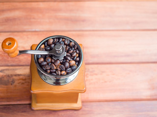 Close up coffee beans organic in wooden grinder homemade on wood table background, top view