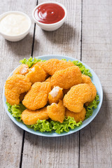 Chicken nuggets in plate on rustic background